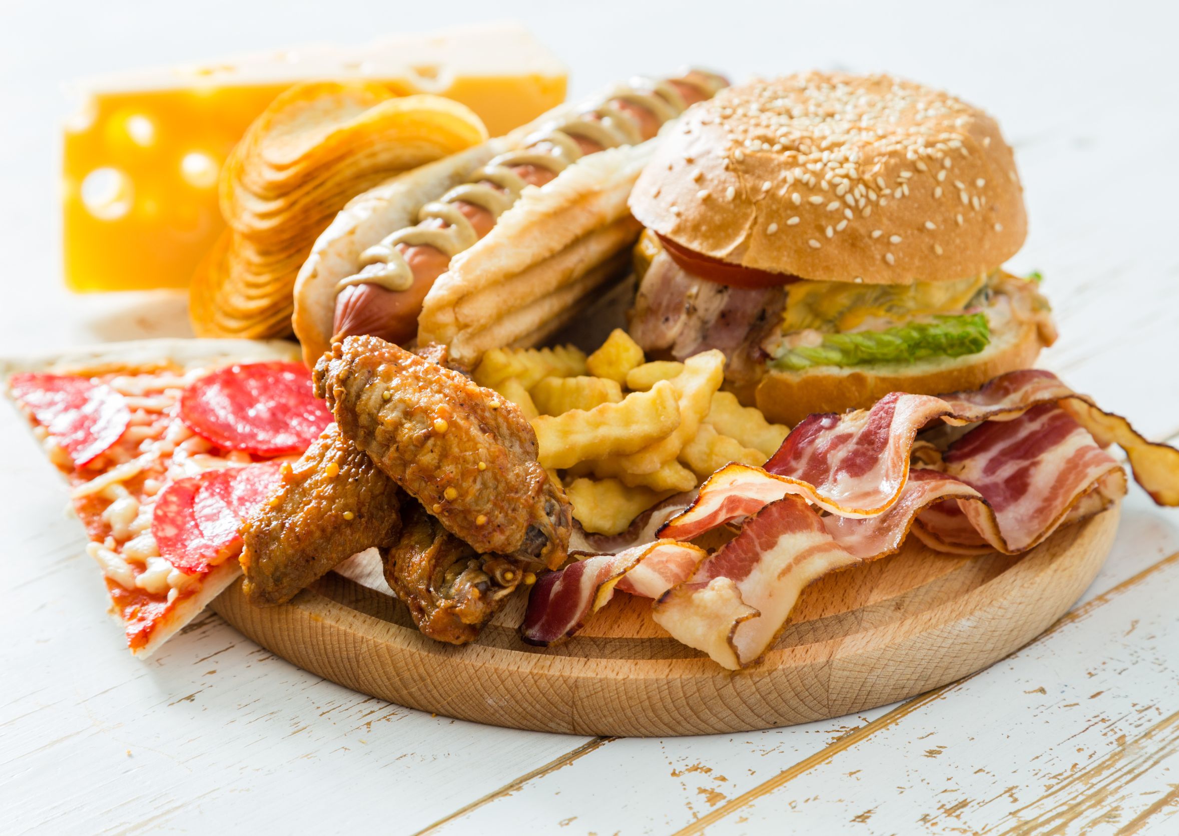 Ongezonde voeding met fastfood, bacon, pizza en friet – risicofactor voor hart en darmen